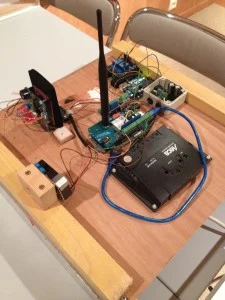 Cartes Arduino, module GSM avec antenne et câblage posés sur une planche.