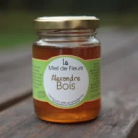 Pot de miel de fleurs avec une étiquette verte personnalisée au nom « Alexandre Bois ».